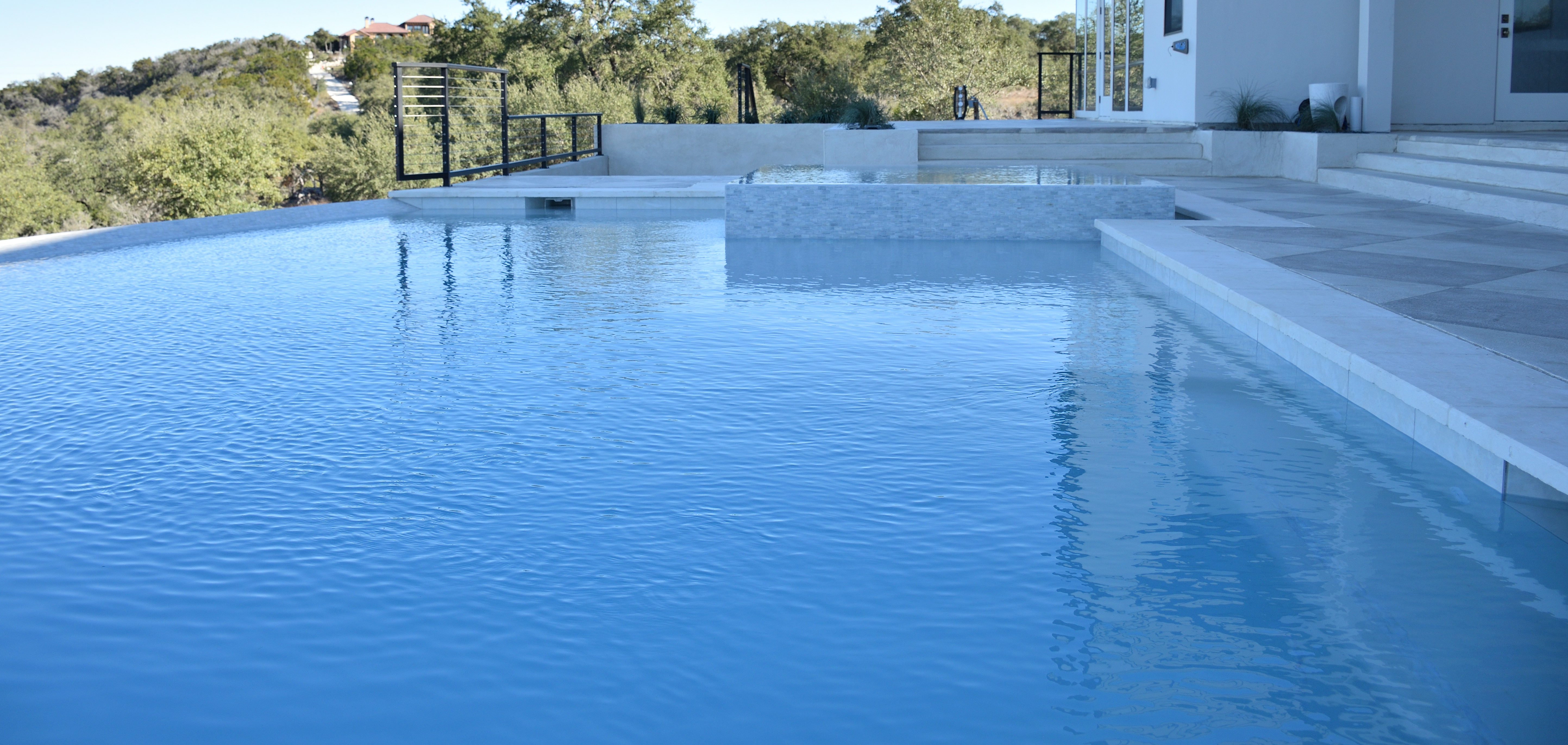 Modern infinity-edge custom pool overlooking the Texas Hill Country, built by J. Oliver Pools