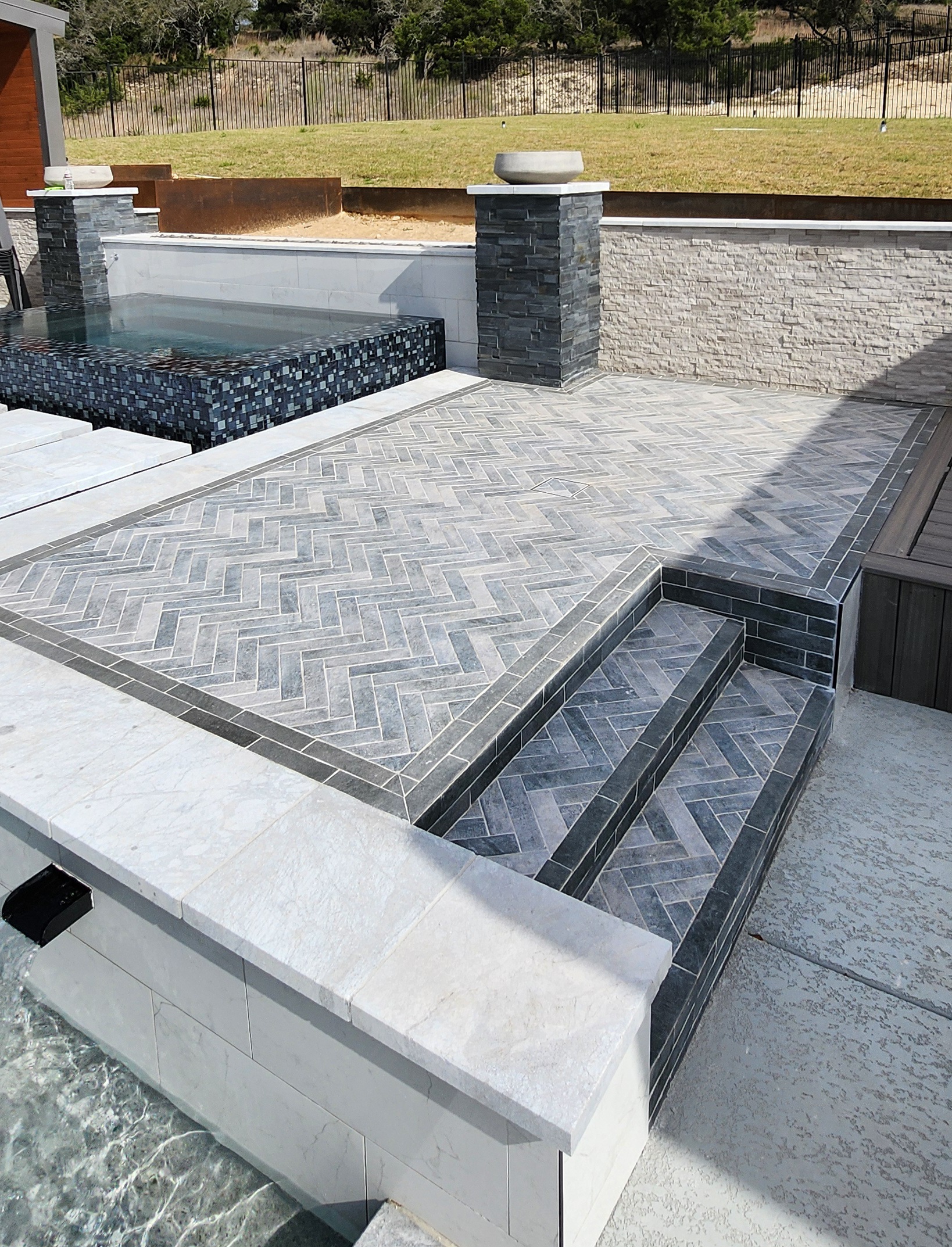 Custom gunite pool with herringbone stone patio and raised spa overlooking the Hill Country in Cordillera Ranch, Boerne TX