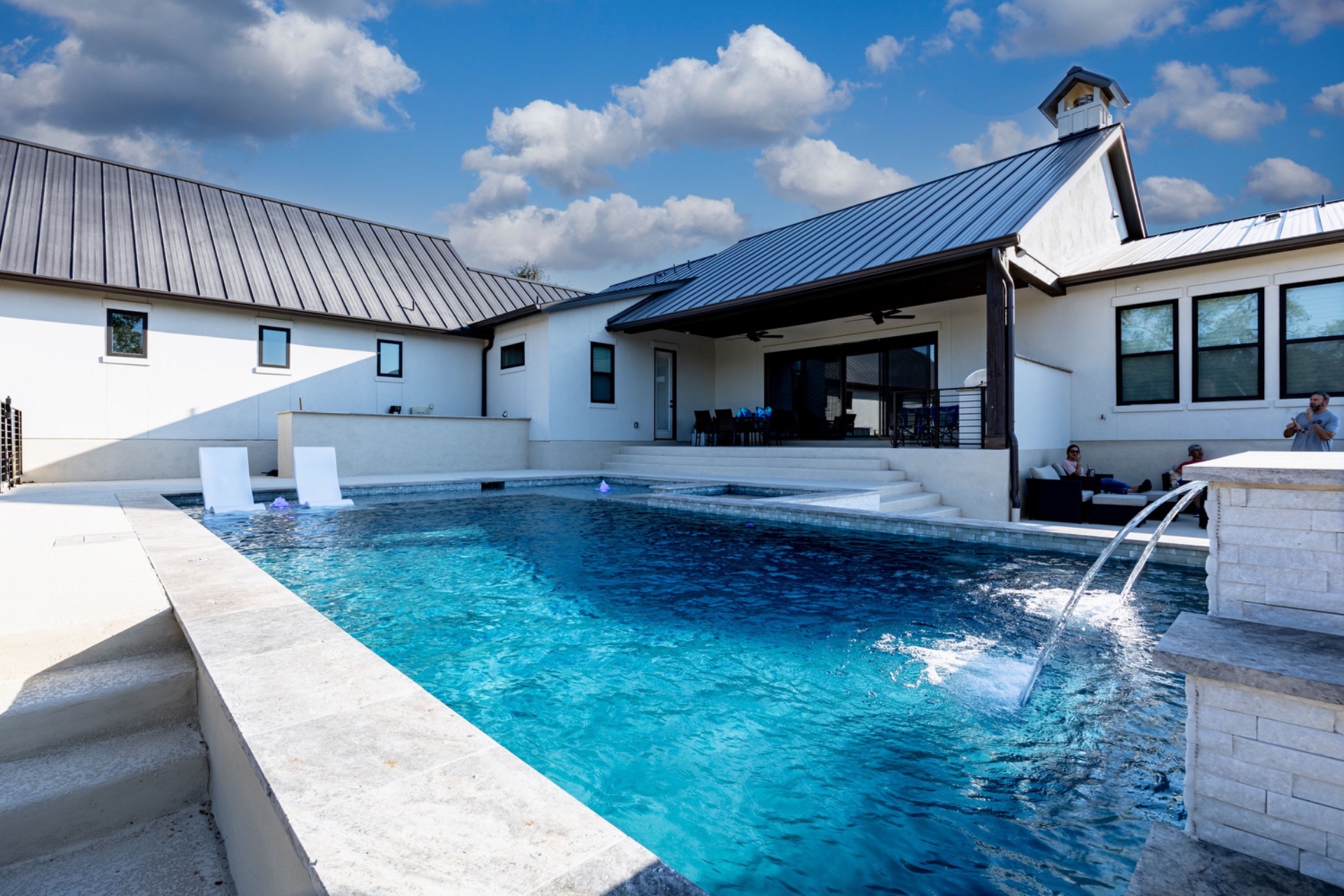 Custom gunite pool with glass-tile waterfall built by J. Oliver Pools in the Texas Hill Country